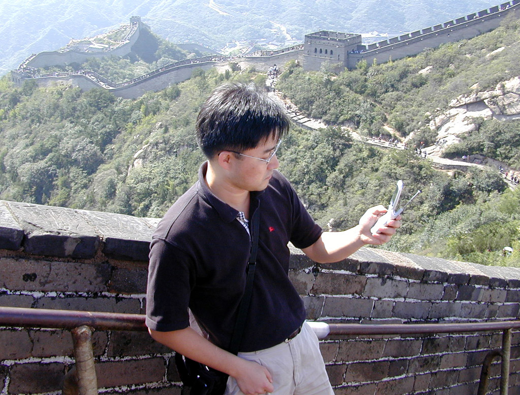 An SK Telecom employee is shown in the Tienemen Plaza of Beijing, China. She is connecting to NATE with her original handset used in Korea. This enables her use of the Data International Roaming Service